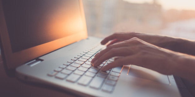 Woman typing on laptop at workplace working in home office hand keyboard