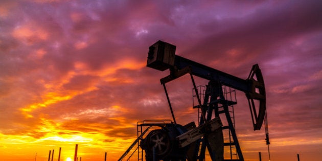 Scenery with oil and gas well pump and dramatic sunset, in East European oil field