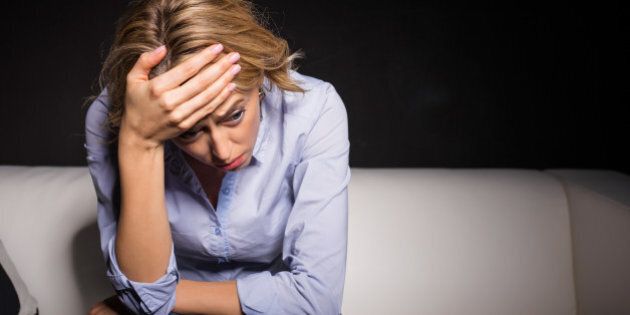 Depressed woman pressing her hand against her forehead