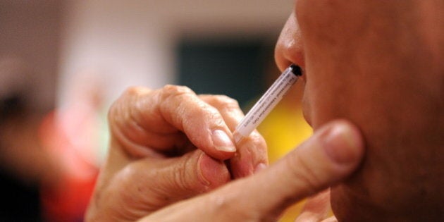 A patient receives a nasal spray vaccine during a clinic held by Montgomery County Health and Human Services for the H1N1 virus on October 9, 2009 at the Dennis Avenue County Health Center in Silver Spring, Maryland. AFP PHOTO / Tim Sloan (Photo credit should read TIM SLOAN/AFP/Getty Images)