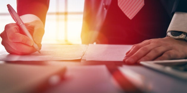 Close up businessman signing documents.