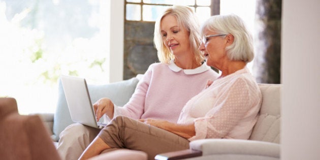 Adult Daughter Helping Senior Mother With Computer At Home