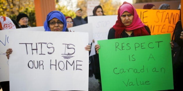 People holds signs during a solidarity march in Toronto November 20, 2015. The march was organized to show solidarity for two Muslim woman were allegedly verbally assaulted on the Toronto subway system on Wednesday, according to local media. REUTERS/Mark Blinch