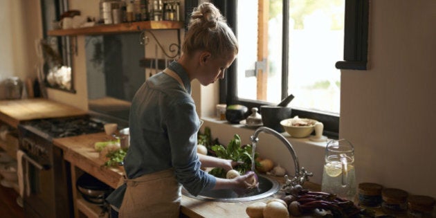 A beautiful young woman preparing a meal in her kitchen