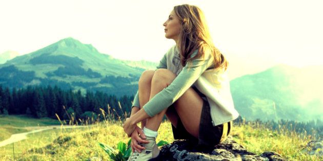 Woman sitting on mountainside