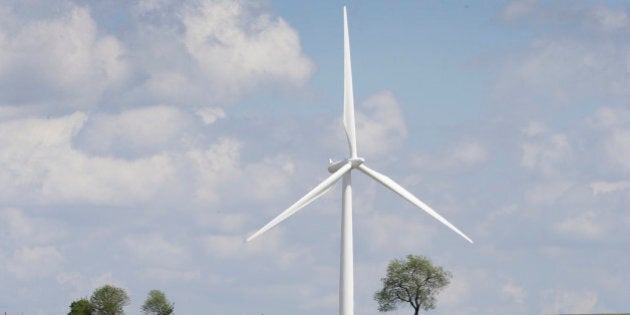 Cattle graze in a pasture near a wind turbine, Monday, June 2, 2014, in Adair, Iowa. Iowa utility officials say the Obama administration's ambitious plan to cut carbon dioxide emissions from power plants is likely to increase costs. Iowa utilities invested heavily in wind power over the past decade and improved the efficiency of existing power plants. (AP Photo/Charlie Neibergall)