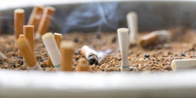 cigarette butts on focus of macro in sand bin