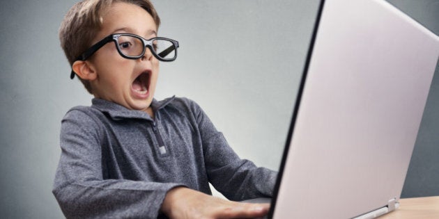 Shocked and surprised boy on the internet with laptop computer concept for amazement, astonishment, making a mistake, stunned and speechless or seeing something he shouldn't see