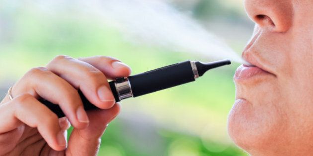 Detail of the electronic cigarette with its vapor similar to traditional cigarette smoke.