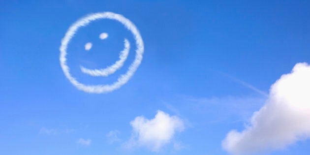 A happy face made from jet trails in a blue sky.