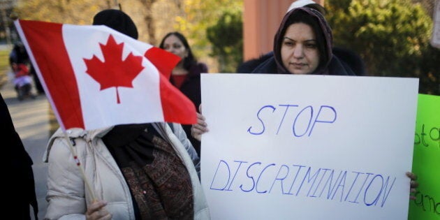 People holds signs during a solidarity march in Toronto November 20, 2015. The march was organized to show solidarity for two Muslim woman were allegedly verbally assaulted on the Toronto subway system on Wednesday, according to local media. REUTERS/Mark Blinch