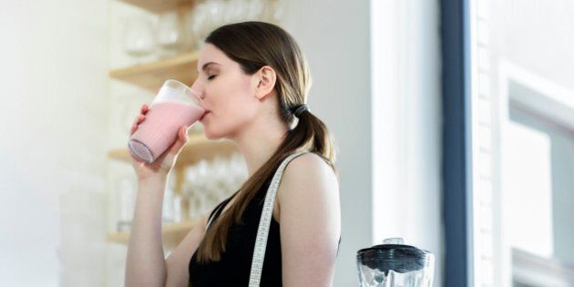 Woman drinking a meal replacement shakes. Horizontal shot.