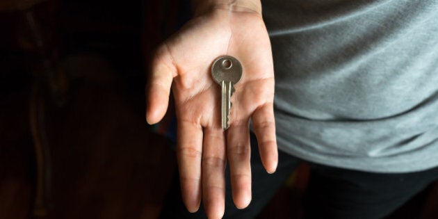 Asian female hand with metal key in palm.