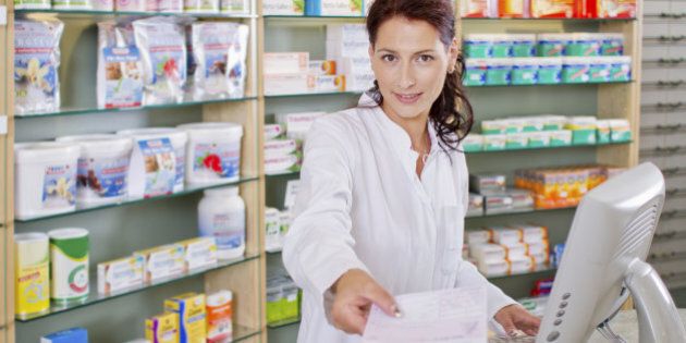 Germany, Brandenburg, Pharmacist holding prescription, smiling, portrait