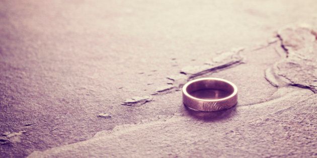 Vintage toned single weeding ring on stone background, conceptual picture.