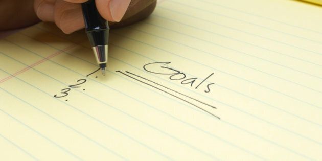 Person writing list of goals, close-up of hand