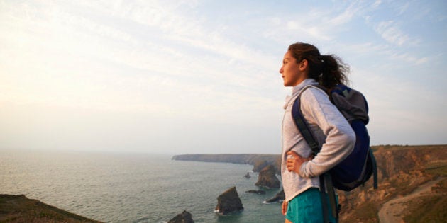 Profile of female hiker on Atlantic coastline.