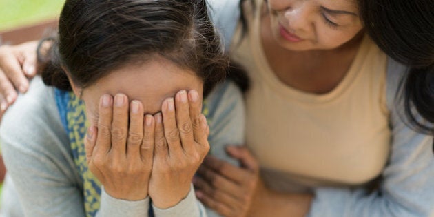 Senior Vietnames woman supporting her crying friend