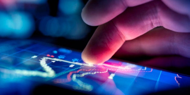 A city businessman using a mobile device to check stocks and market data. Close up shot.