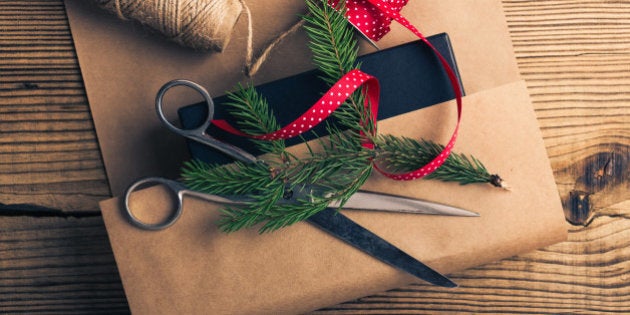 Christmas gift, wrapping craft paper and accessories on wooden table viewed from above