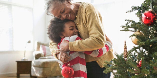 Older woman and granddaughter decorating Christmas tree