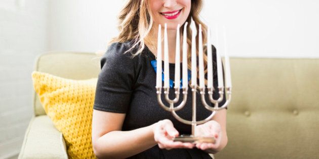 Portrait of young woman holding menorah