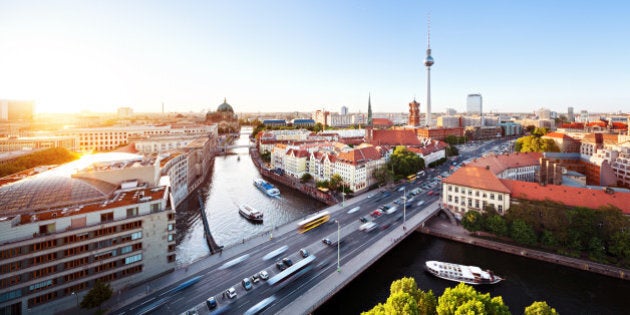 Cityscape from the east side of berlin with sunset.Traffic on a big city and ships on the river spree.