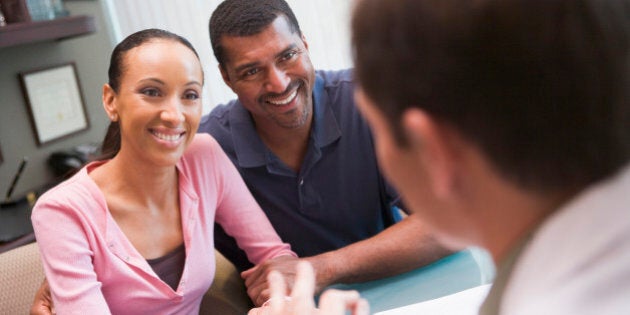 Couple in discussion with doctor in IVF clinic sitting at desk