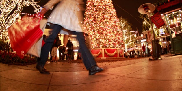 Pedestrian with shopping bags walking in downtown shopping area at Christmas