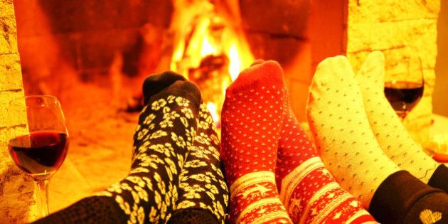 Family wearing woolen socks warming at fireplace