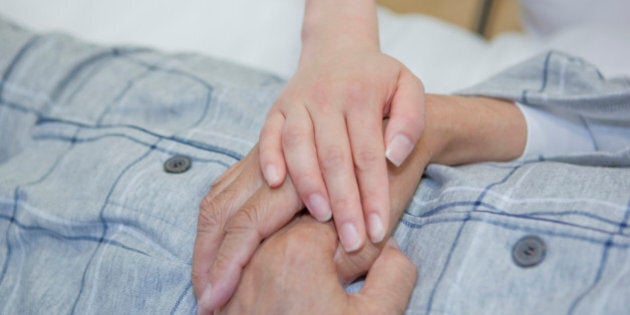 Nurse holding senior man's hand, Kanagawa Prefecture, Honshu, Japan