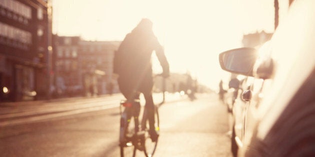 City commuters. High key blurred image of people riding a bike in the street. Unrecognizable faces.