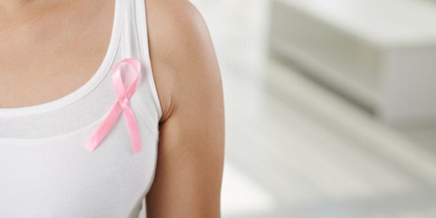 Cropped image of woman wearing pink ribbon, symbol of breast cancer awareness