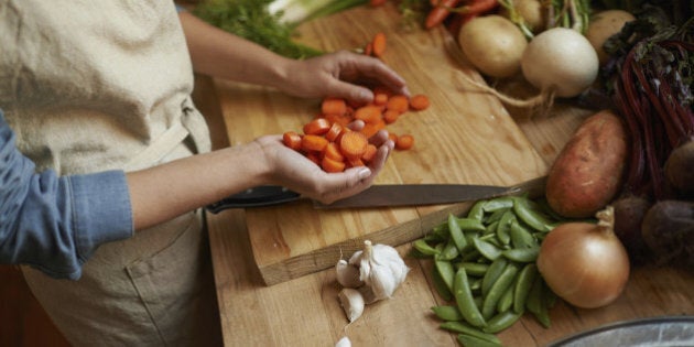 Cropped shot of a woman cutting carrots on a cutting board