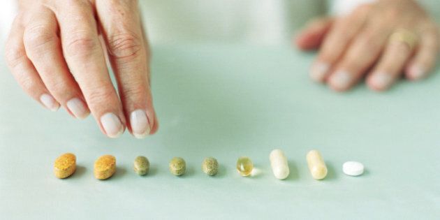 Mature woman arranging pills in row