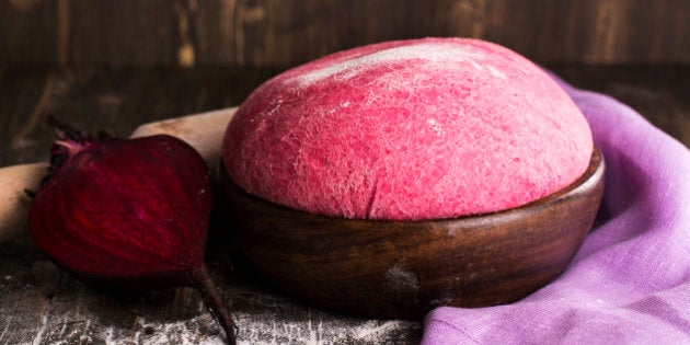 Pink beet dough and ingredients over wooden table. Selective focus. Vintage style