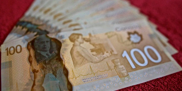 Canadian 100 dollar bills, $100.00,fanned out on red background