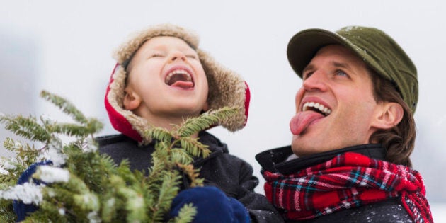 Father and son (6-7) catching snowflakes on tongue, Jersey City, New Jersey, USA