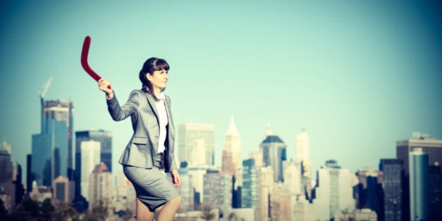 Businesswoman throwing a Boomerang. Investment and gain concept.