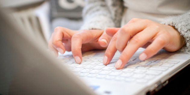 Hands on a keyboard, woman typing on computer.