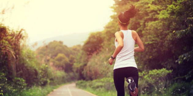 young fitness woman runner running at forest trail