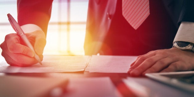 Close up businessman signing documents.