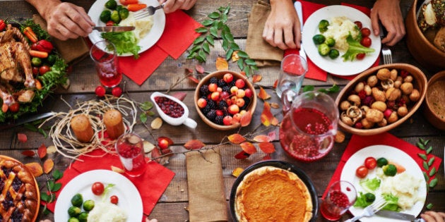 Above view of thanksgiving dinner and family eating at table