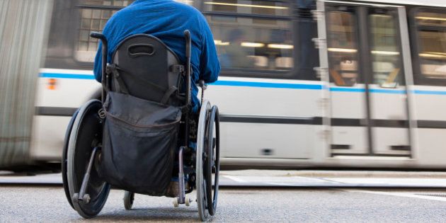Man in wheelchair with spinal cord injury trying to catch a local bus
