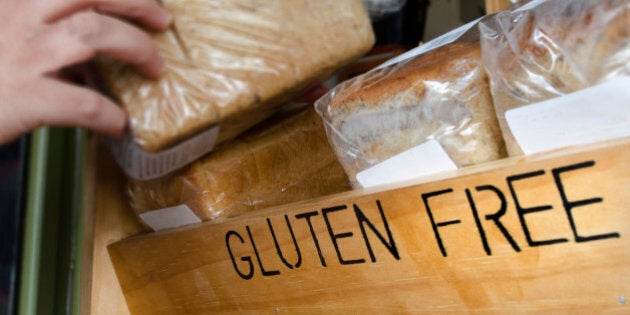 A woman hand picks up a Gluten Free loaf of bread.