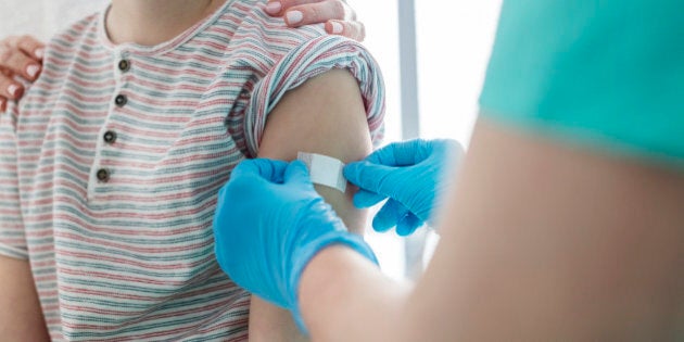 Boy in medical practice receiving band-aid