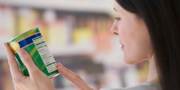 Woman reading label at grocery store