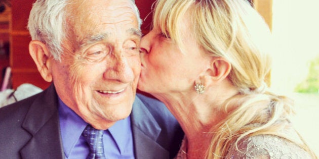 Woman kisses an older man on the cheek