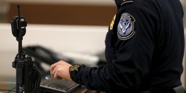 A U.S. Customs and Immigration officer works a new border crossing during the opening day of the Cross Border Xpress pedestrian bridge between San Diego and the Tijuana airport on the facility's opening day in Otay Mesa, California December 9, 2015. The privately run facility allows ticketed passengers to skip long border waits and clear U.S. Customs for a fee. REUTERS/Mike Blake