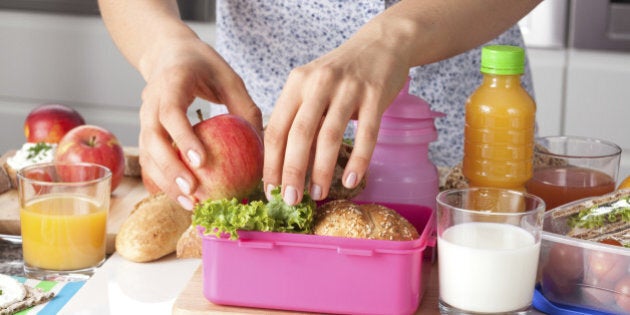 Young woman making school lunch in the morning